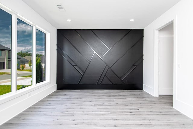 empty room featuring plenty of natural light and light hardwood / wood-style flooring