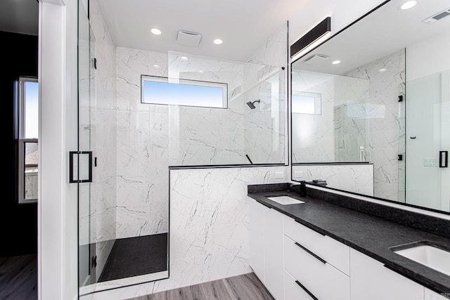 bathroom featuring hardwood / wood-style floors, vanity, and a shower with shower door