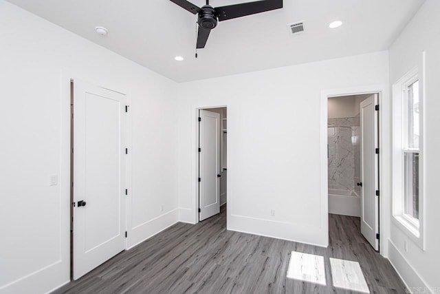 unfurnished bedroom with ensuite bathroom, ceiling fan, and dark hardwood / wood-style floors