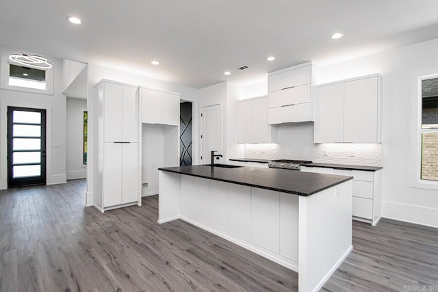 kitchen featuring sink, white cabinets, an island with sink, and light hardwood / wood-style floors