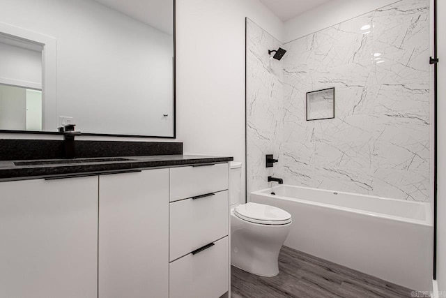 full bathroom featuring toilet, hardwood / wood-style floors, vanity, and tiled shower / bath