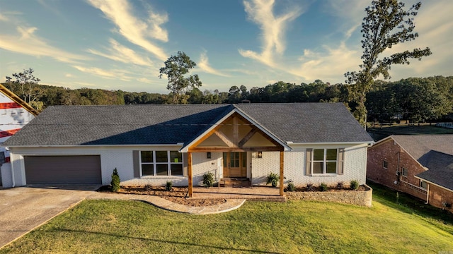 single story home featuring a garage and a front lawn