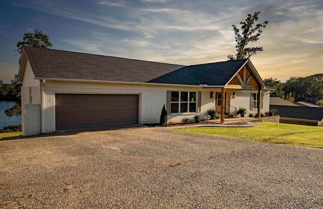 ranch-style home featuring a garage and a lawn