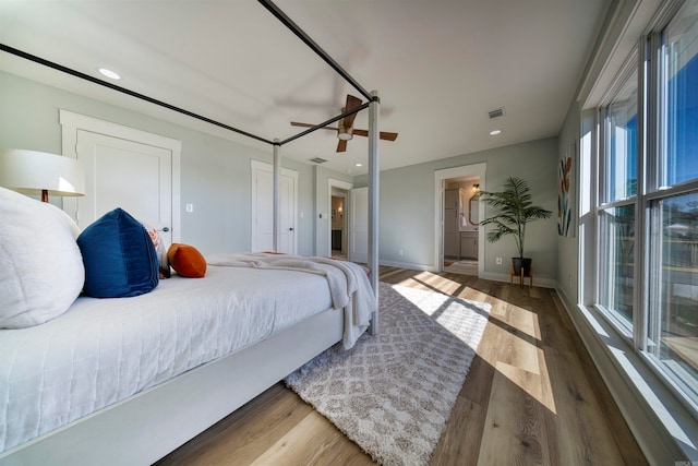 bedroom with ceiling fan, dark hardwood / wood-style floors, and multiple windows