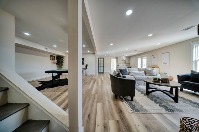 living room with light hardwood / wood-style floors and billiards