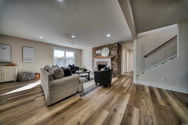 living room with a fireplace and wood-type flooring