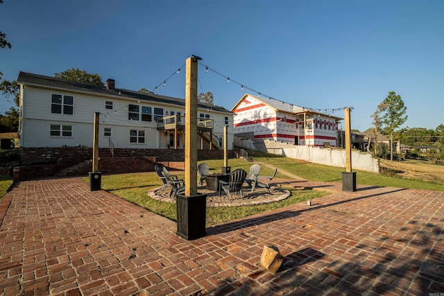 back of property with a patio area and an outdoor fire pit