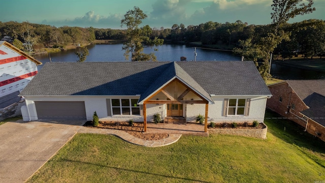 ranch-style home featuring a water view, a front yard, and a garage