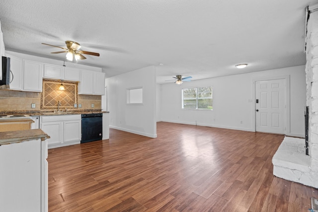 kitchen featuring hardwood / wood-style flooring, a textured ceiling, black dishwasher, tasteful backsplash, and white cabinetry