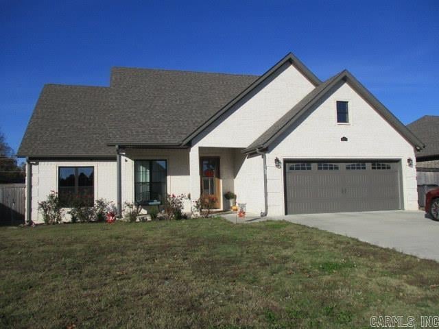 view of front of property featuring a front lawn and a garage