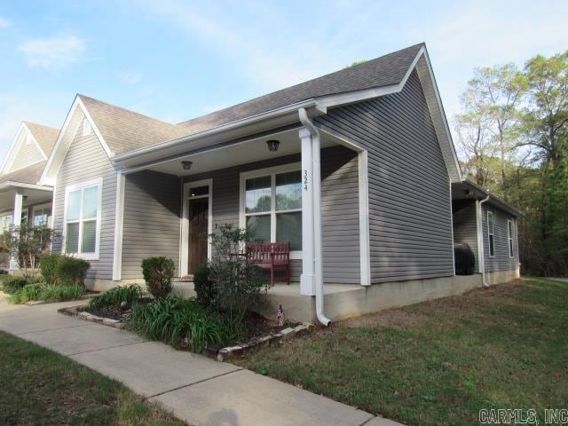 view of property exterior with a yard and a porch