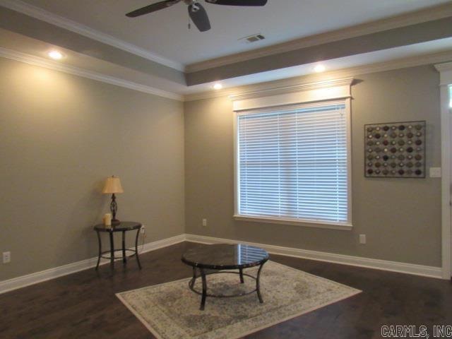 sitting room featuring ceiling fan, ornamental molding, and dark wood-type flooring