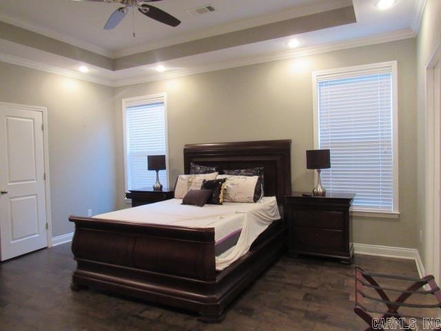 bedroom with a raised ceiling, crown molding, ceiling fan, and dark wood-type flooring