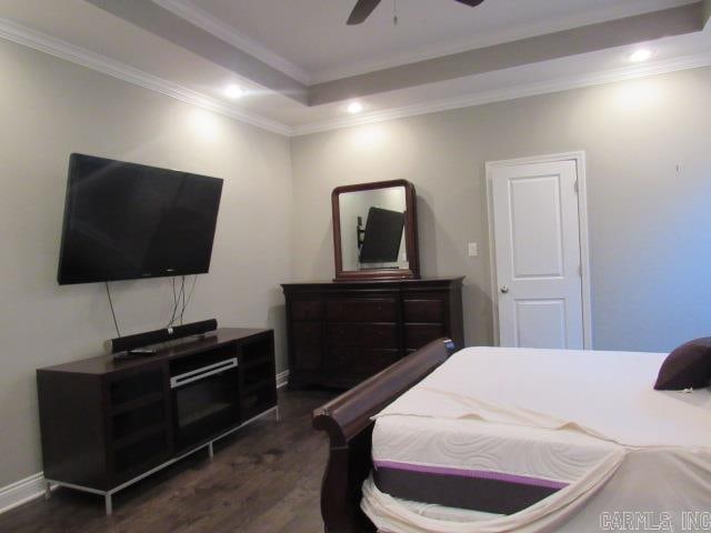 bedroom with ceiling fan, dark hardwood / wood-style flooring, ornamental molding, and a tray ceiling