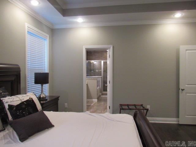 bedroom with ensuite bathroom, dark hardwood / wood-style flooring, and crown molding