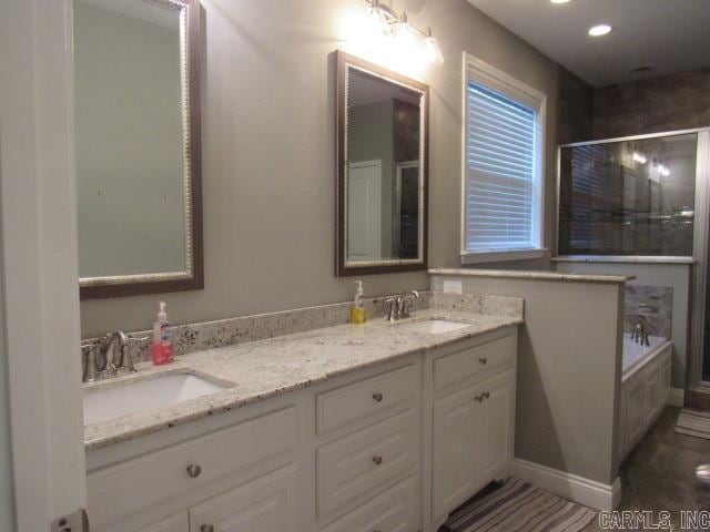 bathroom with vanity and independent shower and bath