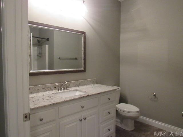 bathroom featuring vanity, toilet, and walk in shower