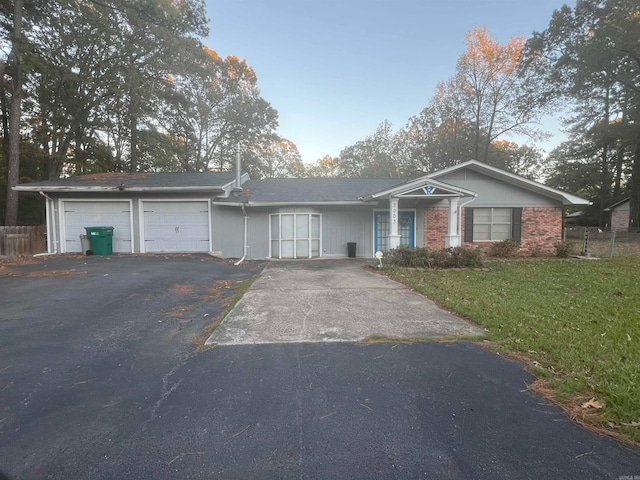 ranch-style house featuring a garage and a front lawn