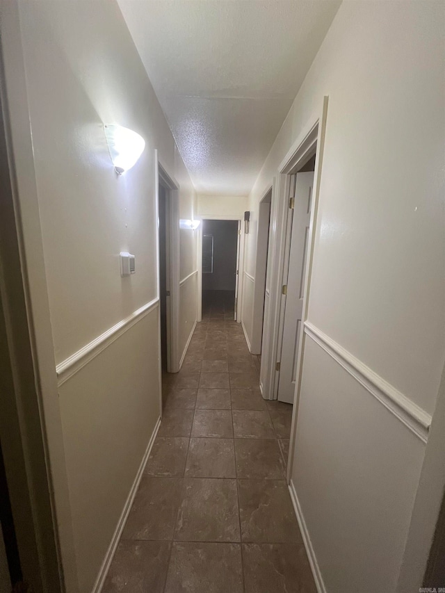 corridor with dark tile patterned flooring