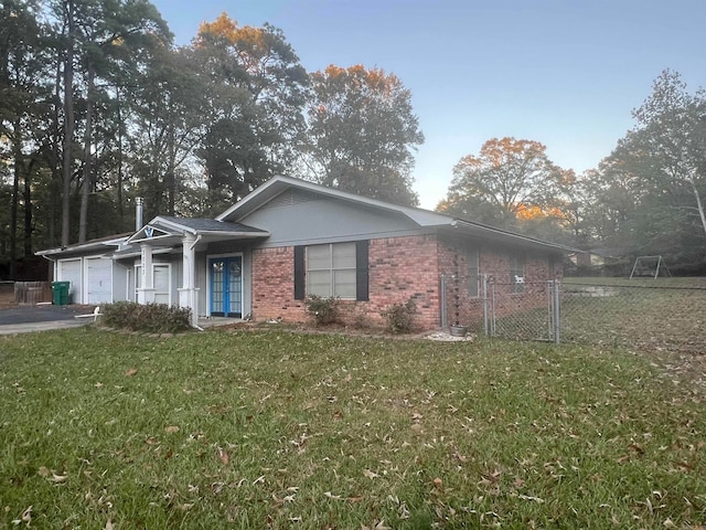 ranch-style home with a garage and a front lawn