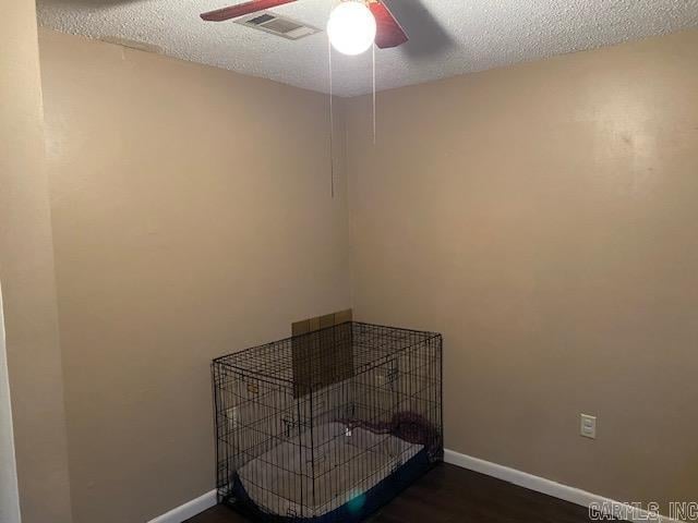 interior space with ceiling fan, dark hardwood / wood-style flooring, and a textured ceiling