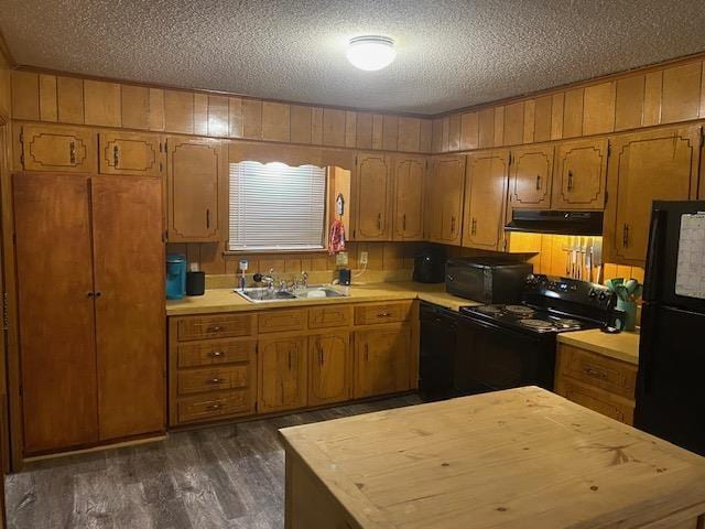 kitchen featuring dark hardwood / wood-style flooring, sink, a textured ceiling, and black appliances