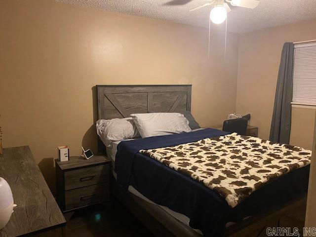 bedroom featuring ceiling fan and a textured ceiling