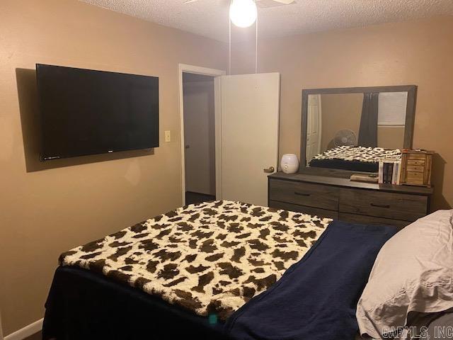 bedroom with a textured ceiling and ceiling fan