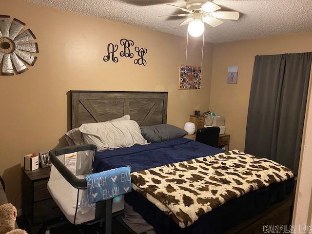 bedroom featuring ceiling fan and a textured ceiling