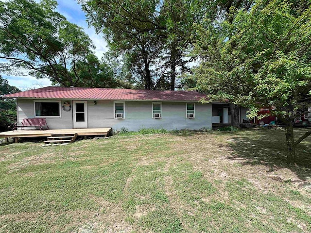 rear view of house with a lawn and a wooden deck