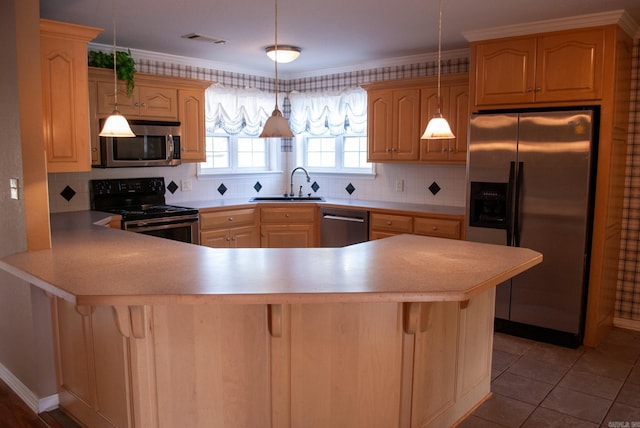 kitchen featuring kitchen peninsula, appliances with stainless steel finishes, backsplash, sink, and decorative light fixtures