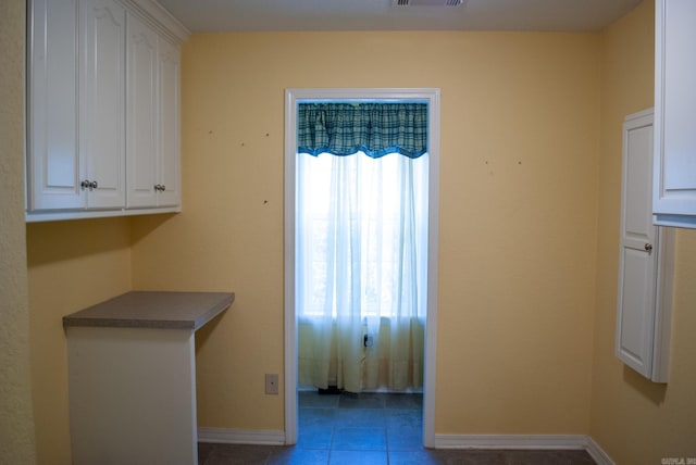 interior space featuring plenty of natural light and dark tile patterned floors