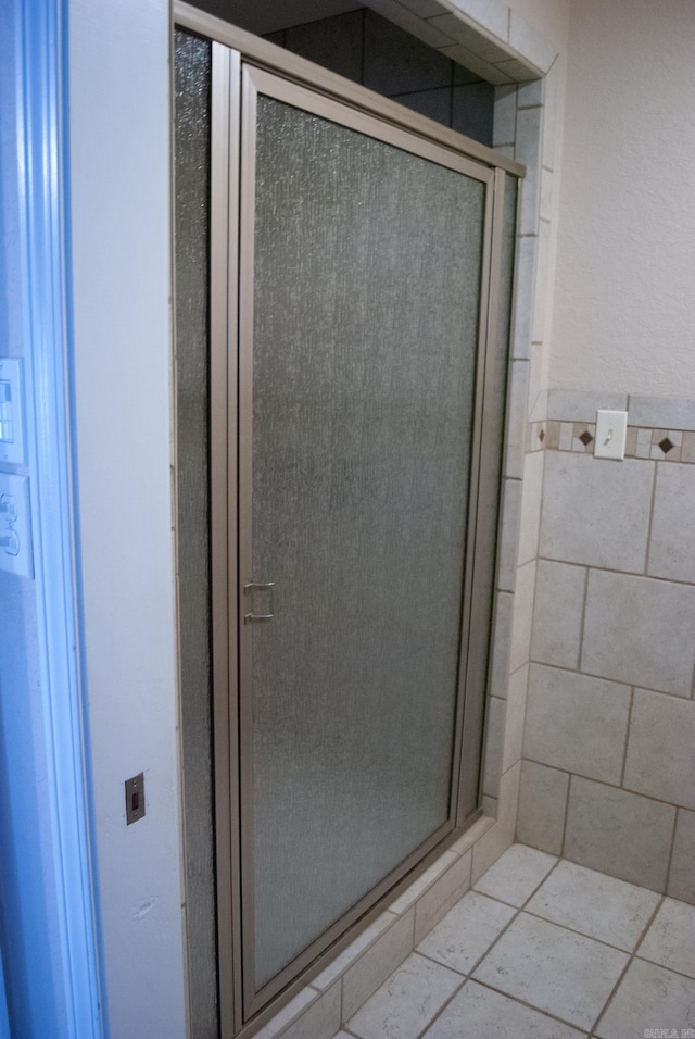 bathroom with tile patterned flooring and a shower with shower door