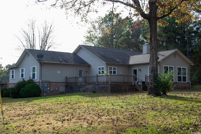 rear view of property featuring a lawn and a wooden deck