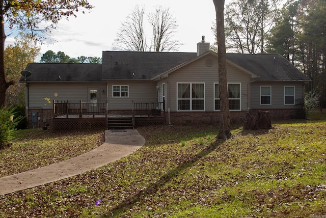 back of property with a wooden deck and a yard