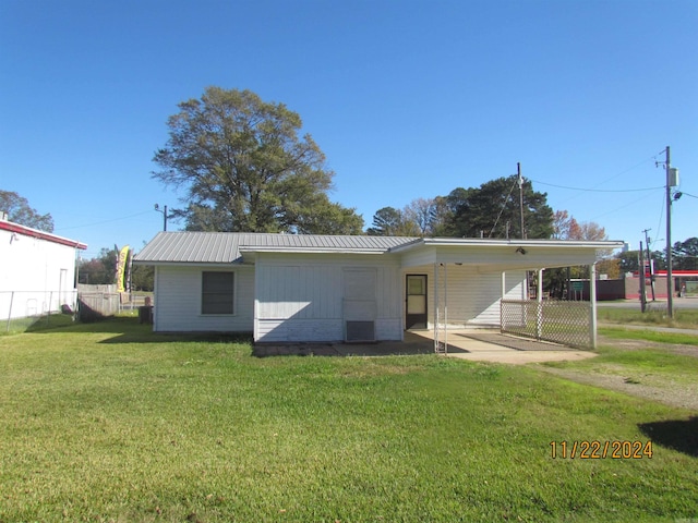 rear view of house featuring a yard and a carport