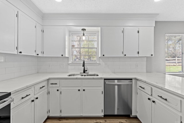 kitchen with appliances with stainless steel finishes, light stone counters, a textured ceiling, sink, and white cabinetry