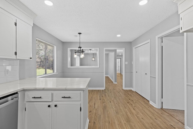 kitchen featuring dishwasher, hanging light fixtures, white cabinetry, light hardwood / wood-style floors, and kitchen peninsula