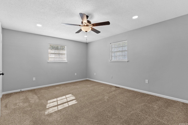 carpeted empty room featuring ceiling fan and a textured ceiling