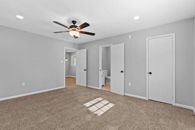 unfurnished bedroom featuring carpet, ensuite bathroom, ceiling fan, and a textured ceiling