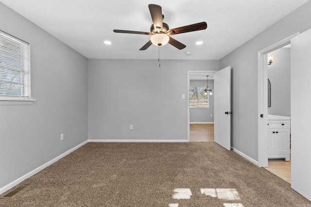 unfurnished bedroom featuring light colored carpet and ceiling fan