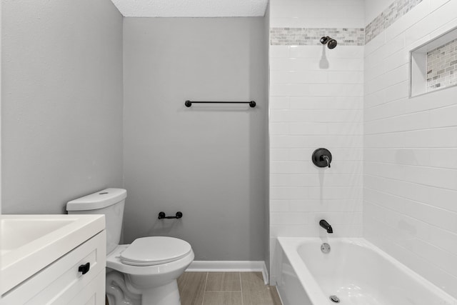 full bathroom featuring tiled shower / bath, vanity, a textured ceiling, and toilet