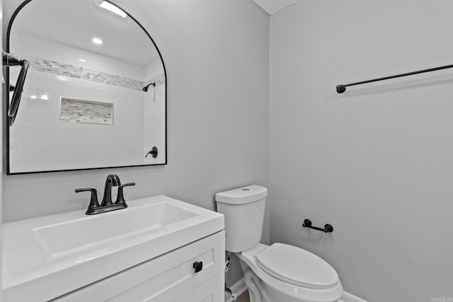 bathroom featuring vanity, toilet, and a textured ceiling