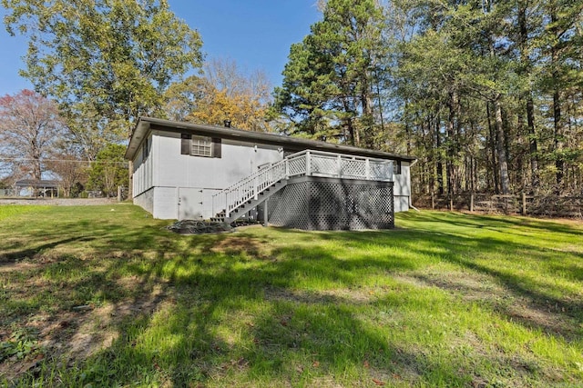 back of property with a deck and a lawn