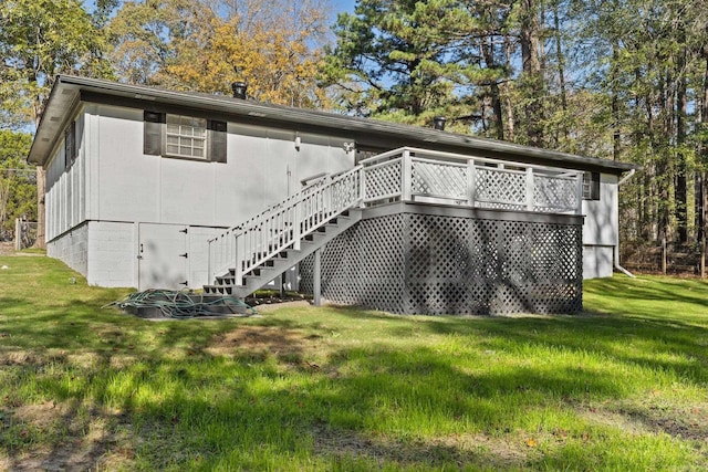 back of house featuring a lawn and a deck