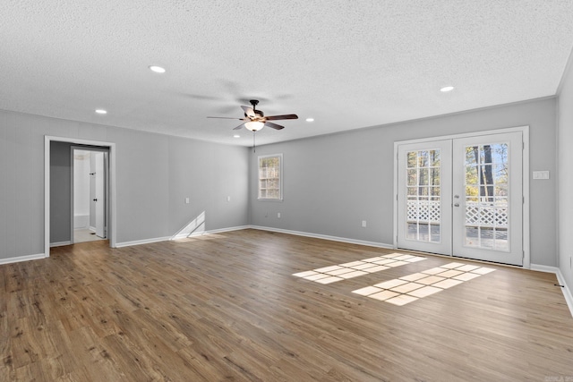 spare room with hardwood / wood-style flooring, plenty of natural light, a textured ceiling, and french doors