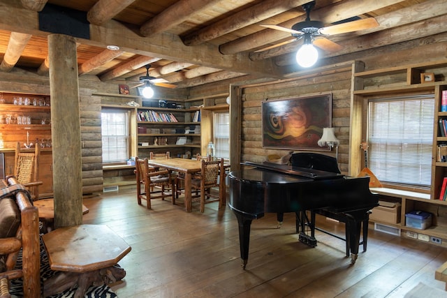 misc room featuring decorative columns, rustic walls, wood ceiling, beam ceiling, and hardwood / wood-style flooring