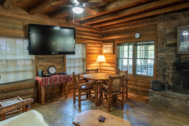 dining room featuring hardwood / wood-style flooring, ceiling fan, rustic walls, beam ceiling, and wood ceiling