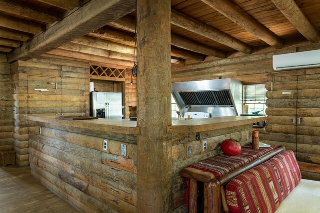 interior space featuring a wall mounted air conditioner, stainless steel refrigerator with ice dispenser, log walls, beam ceiling, and wood-type flooring