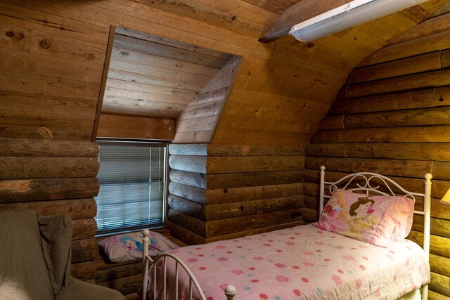 bedroom with log walls, lofted ceiling, and wood ceiling